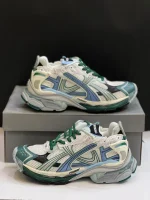 کتونی بالنسیاگا رانر وایت گرین بلو با مش سفید و الگوی گرافیتی در پس‌زمینه روشن