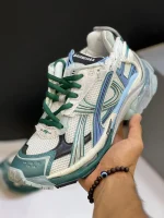 کتونی بالنسیاگا رانر وایت گرین بلو با مش سفید و الگوی گرافیتی در پس‌زمینه روشن