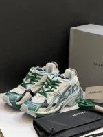 کتونی بالنسیاگا رانر وایت گرین بلو با مش سفید و الگوی گرافیتی در پس‌زمینه روشن