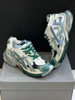 کتونی بالنسیاگا رانر وایت گرین بلو با مش سفید و الگوی گرافیتی در پس‌زمینه روشن