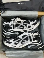 کتونی بالنسیاگا رانر مشکی سفید با مش تیره و روکش‌های سفید در پس‌زمینه روشن