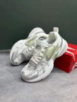 کتونی نایکی V2K Run وایت/متالیک سیلور/پیور پلاتینیوم با مش سفید و روکشهای نقرهای در پسزمینه روشن