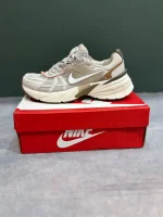 کتونی نایکی V2K Run عسلی با مش گرم و روکش‌های شفاف در پس‌زمینه روشن