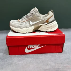 کتونی نایکی V2K Run عسلی با مش گرم و روکش‌های شفاف در پس‌زمینه روشن