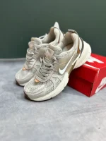 کتونی نایکی V2K Run عسلی با مش گرم و روکش‌های شفاف در پس‌زمینه روشن