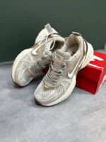 کتونی نایکی V2K Run عسلی با مش گرم و روکش‌های شفاف در پس‌زمینه روشن