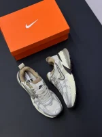 کتونی نایکی V2K Run اوروود براون با مش قهوهای و روکشهای شفاف در پسزمینه روشن