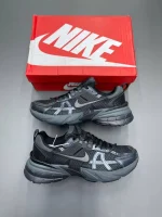 کتونی نایکی V2K Run بلک/دارک اسمک گری با مش تیره و روکشهای شفاف در پسزمینه روشن