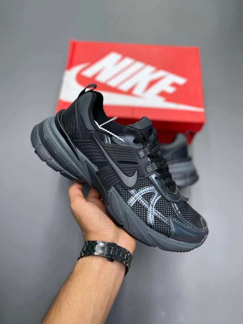 nike-v2k-run (5) کتونی نایکی V2K Run بلک/دارک اسمک گری با مش تیره و روکشهای شفاف در پسزمینه روشن