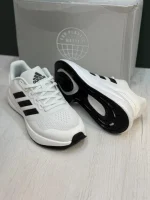 کتونی آدیداس رانفالکن 5 وایت بلک با مش سفید و روکش‌های مشکی در پس‌زمینه روشن