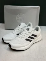 کتونی آدیداس رانفالکن 5 وایت بلک با مش سفید و روکش‌های مشکی در پس‌زمینه روشن