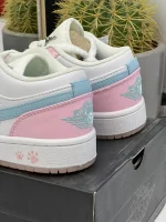 کتونی نایکی ایر جردن 1 لو پاو پرینت با چرم سفید و ردپاهای صورتی در پسزمینه روشن