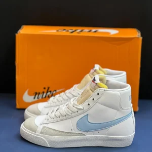 کتونی نایکی بلازر مید 77 وینتیج وایت اند بلو با چرم سفید و سووش‌های آبی در پس‌زمینه روشن