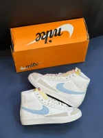 کتونی نایکی بلازر مید 77 وینتیج وایت اند بلو با چرم سفید و سووشهای آبی در پسزمینه روشن