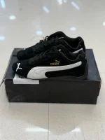 کتونی پوما اسپیدکت بلک با سُئد مشکی و لوگوی گربه در پسزمینه روشن