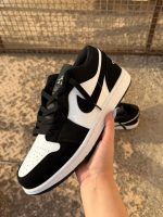 کتونی نایکی جردن 1 لو پاندا با چرم مشکی و سووشهای سفید در پسزمینه روشن