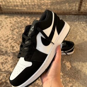 کتونی نایکی جردن 1 لو پاندا با چرم مشکی و سووشهای سفید در پسزمینه روشن