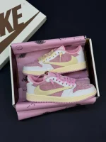 کتونی نایکی جردن 1 لو ترویس اسکات شای پینک با چرم سیل و سُئد صورتی در پسزمینه روشن