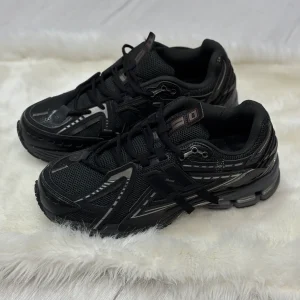 کتونی نیوبالانس ۱۹۰۶A مشکی با رویه مش و چرم مشکی یکدست، Swoosh خاکستری ملایم و زیره ABZORB